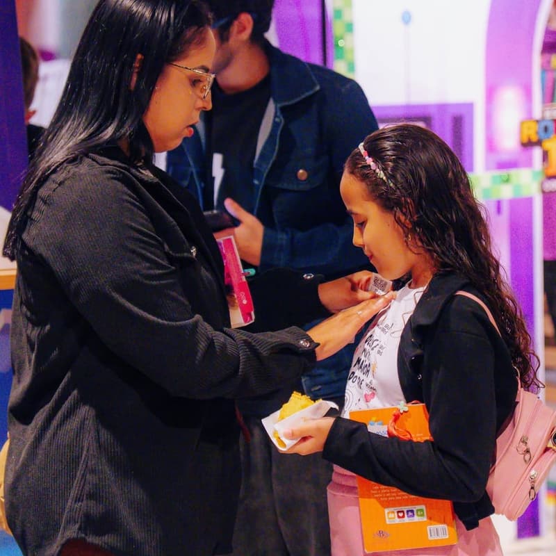 Mãe colocando a etiqueta do Rocket ID na filha na entrada